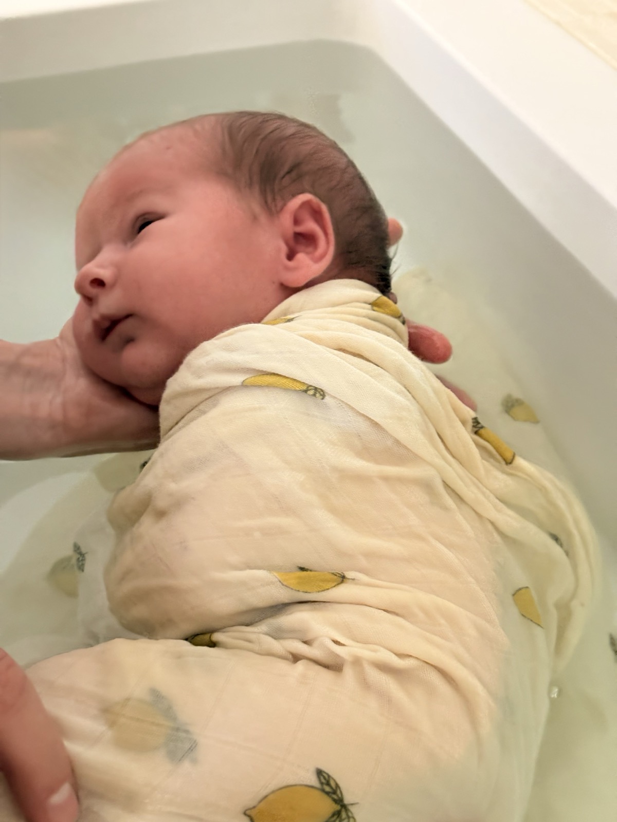 Bébé enveloppé dans un lange pendant son bain thérapeutique
